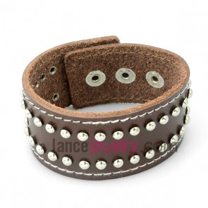 Trendy bracelet with brown leather decorated many small size rivets and snap fastener 
