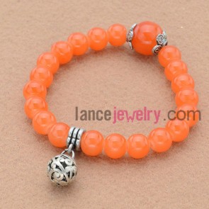 Striking orange color bead bracelet with nice pendant.