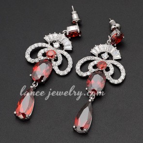 Innovative brass alloy earrings decorated with pendants of red cubic zirconia