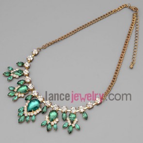 Charming necklace with gold metal chain and brass parts and shiny rhinestone and green crystal with special shape
