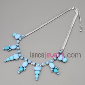 Trendy necklace with silver metal chain and brass parts and blue resin pendant