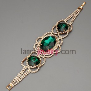 Retro bracelet with brass claw chain decorated shiny rhinestone and green crystal 
