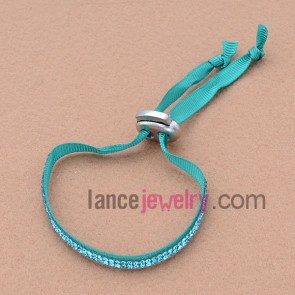 Fabric based bracelet with rhinestone beads and plastic clasp