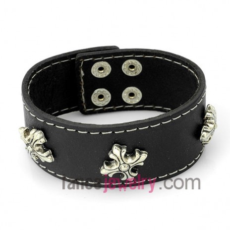 Fashion bracelet with brown leather decorated many alloy shapes and snap fastener 
