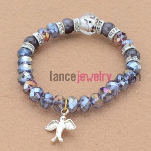 Glittering bead bracelet with bird pendant.