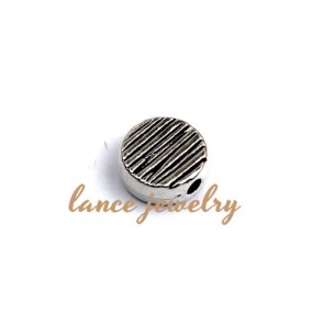 Zinc alloy pendant, a 11mm round bead with straight lines printed on tha face, a hole in the side